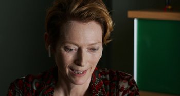 Movie still from “The Human Voice” (2020), directed by Pedro Almodóvar – A person wearing headphones; Close Up shot, Over the shoulder angle