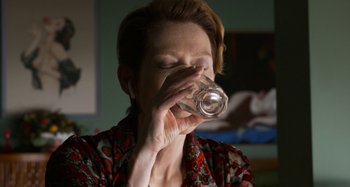Movie still from “The Human Voice” (2020), directed by Pedro Almodóvar – A woman drinking a glass of water from a bottle; Close Up shot, Over the shoulder angle