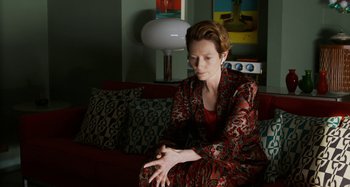Movie still from “The Human Voice” (2020), directed by Pedro Almodóvar – A woman sitting on top of a couch in a living room; Medium shot, High angle