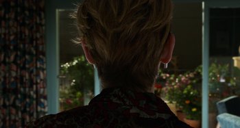 Movie still from “The Human Voice” (2020), directed by Pedro Almodóvar – The back of a woman's head with flowers in the background; Close Up shot, Over the shoulder angle