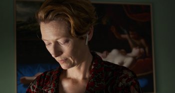 Movie still from “The Human Voice” (2020), directed by Pedro Almodóvar – A person wearing a floral shirt; Close Up shot, Over the shoulder angle