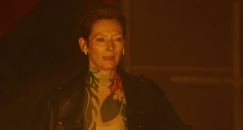 Movie still from “The Human Voice” (2020), directed by Pedro Almodóvar – A woman in a black leather jacket and a floral shirt; Close Up shot, Over the shoulder angle