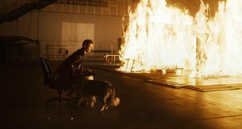 Movie still from “The Human Voice” (2020), directed by Pedro Almodóvar – A man and a dog in front of a burning building; Wide shot, Over the shoulder angle