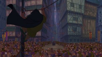 Movie still from “The Hunchback of Notre Dame” (1996), directed by Gary Trousdale – A man hanging from a pole in front of a crowd of people; Wide shot, Low angle