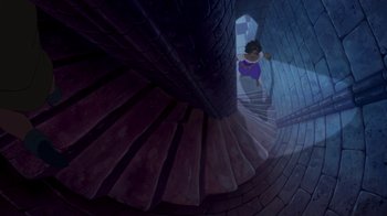 Movie still from “The Hunchback of Notre Dame” (1996), directed by Gary Trousdale – A person climbing up a spiral staircase in a building; Extreme Wide shot, Overhead angle