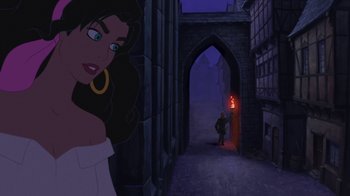 Movie still from “The Hunchback of Notre Dame” (1996), directed by Gary Trousdale – A woman standing in front of an archway with a man in the background; Medium shot, Over the shoulder angle