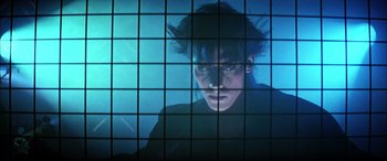 Movie still from “The Hunger” (1983), directed by Tony Scott – A man is looking out of a window at night; Close Up shot, Low angle