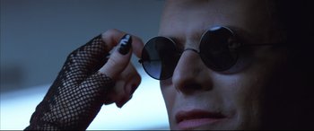 Movie still from “The Hunger” (1983), directed by Tony Scott – A person wearing a pair of sunglasses and a fishnet glove; Extreme Close Up shot, Low angle