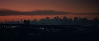 Movie still from “The Hunger” (1983), directed by Tony Scott – A view of a city skyline at sunset; Extreme Wide shot, Low angle