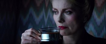 Movie still from “The Hunger” (1983), directed by Tony Scott – A woman holding a cup of coffee in her hands; Close Up shot, Over the shoulder angle