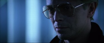 Movie still from “The Hunger” (1983), directed by Tony Scott – A person wearing glasses; Close Up shot, Low angle