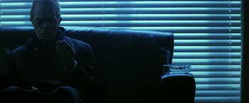 Movie still from “The Hunger” (1983), directed by Tony Scott – A black leather couch in front of a window with blinds; Medium shot, Low angle