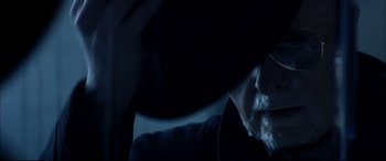 Movie still from “The Hunger” (1983), directed by Tony Scott – A person in a car wearing headphones; Extreme Close Up shot, Low angle