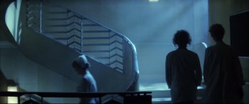 Movie still from “The Hunger” (1983), directed by Tony Scott – Two people walking up a flight of stairs in the dark; Wide shot, Low angle