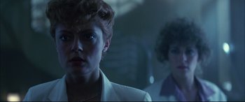 Movie still from “The Hunger” (1983), directed by Tony Scott – A woman in a white jacket standing next to another woman in a white jacket; Close Up shot, Low angle