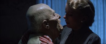 Movie still from “The Hunger” (1983), directed by Tony Scott – A woman touching the face of a statue of a man; Close Up shot, Low angle
