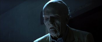 Movie still from “The Hunger” (1983), directed by Tony Scott – An old man with wrinkled skin and a bald head; Close Up shot, Low angle