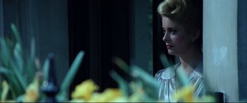 Movie still from “The Hunger” (1983), directed by Tony Scott – A woman in a white dress looking out of a window; Close Up shot, Low angle