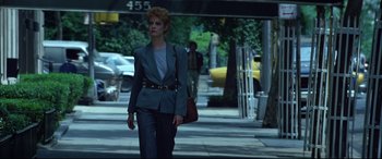Movie still from “The Hunger” (1983), directed by Tony Scott – A woman walking down the street with a purse in her hand; Medium shot, Low angle
