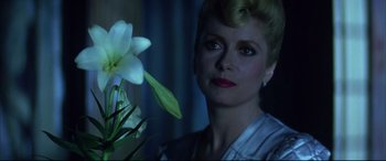 Movie still from “The Hunger” (1983), directed by Tony Scott – A person with a flower; Close Up shot, Low angle