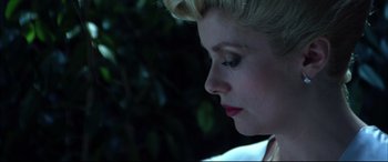 Movie still from “The Hunger” (1983), directed by Tony Scott – A person's face with a tree in the background; Close Up shot, Low angle