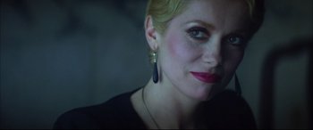 Movie still from “The Hunger” (1983), directed by Tony Scott – A person wearing a necklace and earrings; Close Up shot, Low angle