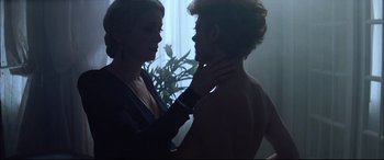 Movie still from “The Hunger” (1983), directed by Tony Scott – A man and a woman touching each other's neck; Medium shot, Over the shoulder angle