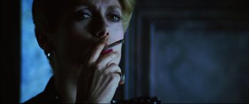 Movie still from “The Hunger” (1983), directed by Tony Scott – A person smoking a cigarette; Close Up shot, Low angle