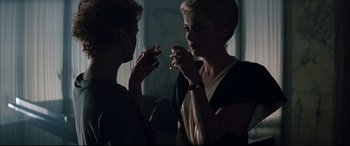 Movie still from “The Hunger” (1983), directed by Tony Scott – Two women are drinking wine in a dark room; Close Up shot, Over the shoulder angle