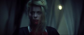 Movie still from “The Hunger” (1983), directed by Tony Scott – A woman with blood on her face is looking at the camera; Close Up shot, High angle