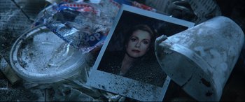 Movie still from “The Hunger” (1983), directed by Tony Scott – An old photo of a woman is on a pile of trash; Close Up shot, Overhead angle