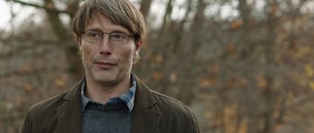 Movie still from “The Hunt” (2012), directed by Thomas Vinterberg – A person wearing glasses and a jacket; Close Up shot, Over the shoulder angle