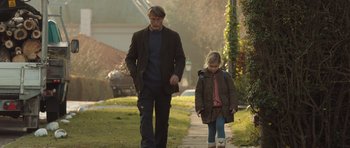 Movie still from “The Hunt” (2012), directed by Thomas Vinterberg – A man and a little girl walking down a sidewalk; Wide shot, Low angle