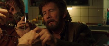Movie still from “The Hunt” (2012), directed by Thomas Vinterberg – A person holding a wine glass; Close Up shot, Over the shoulder angle