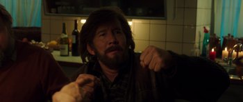 Movie still from “The Hunt” (2012), directed by Thomas Vinterberg – A man with long hair and a beard is looking at the camera; Close Up shot, Over the shoulder angle