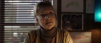 Movie still from “The Hunt” (2012), directed by Thomas Vinterberg – An older woman wearing glasses and wearing a sweater; Close Up shot, Over the shoulder angle