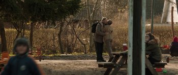 Movie still from “The Hunt” (2012), directed by Thomas Vinterberg – A man and a woman kissing in a park; Wide shot, Over the shoulder angle