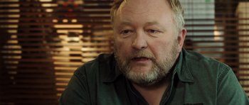 Movie still from “The Hunt” (2012), directed by Thomas Vinterberg – A person wearing a green shirt; Close Up shot, Over the shoulder angle