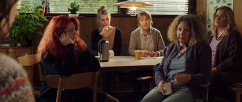 Movie still from “The Hunt” (2012), directed by Thomas Vinterberg – A group of people sitting at a table; Medium shot, Over the shoulder angle
