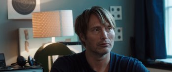 Movie still from “The Hunt” (2012), directed by Thomas Vinterberg – A person sitting in a room; Close Up shot, Over the shoulder angle