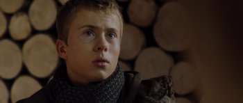 Movie still from “The Hunt” (2012), directed by Thomas Vinterberg – A young man wearing a scarf and a jacket; Close Up shot, Low angle