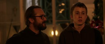 Movie still from “The Hunt” (2012), directed by Thomas Vinterberg – A man with a beard and glasses and a man with a beard and glasses; Close Up shot, Over the shoulder angle