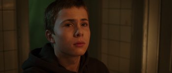 Movie still from “The Hunt” (2012), directed by Thomas Vinterberg – A young boy is looking into the distance; Close Up shot, Low angle