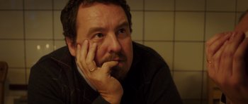 Movie still from “The Hunt” (2012), directed by Thomas Vinterberg – A person with his hand under his chin; Close Up shot, Over the shoulder angle