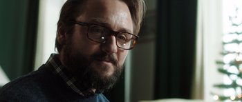 Movie still from “The Hunt” (2012), directed by Thomas Vinterberg – A person wearing glasses and a sweater; Close Up shot, Low angle