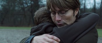 Movie still from “The Hunt” (2012), directed by Thomas Vinterberg – A person hugging another person; Close Up shot, Over the shoulder angle