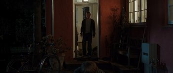 Movie still from “The Hunt” (2012), directed by Thomas Vinterberg – A man standing at the door of a house at night; Wide shot, Over the shoulder angle