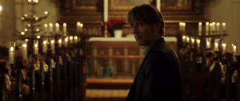 Movie still from “The Hunt” (2012), directed by Thomas Vinterberg – A man in a suit standing in front of a fireplace; Close Up shot, Low angle