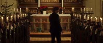 Movie still from “The Hunt” (2012), directed by Thomas Vinterberg – A man standing in front of a church altar; Wide shot, Low angle