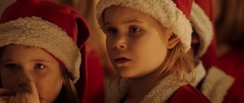 Movie still from “The Hunt” (2012), directed by Thomas Vinterberg – A little girl wearing a santa clause hat; Close Up shot, Over the shoulder angle